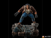 Iron Studios 1/10 Logan statue showing Wolverine in a brown leather jacket and blue jeans with claws extended on a base.