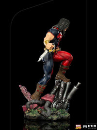 Side view of the 26cm Iron Studios Warpath 1/10 scale statue, featuring the hero in blue and red gear with a knife.