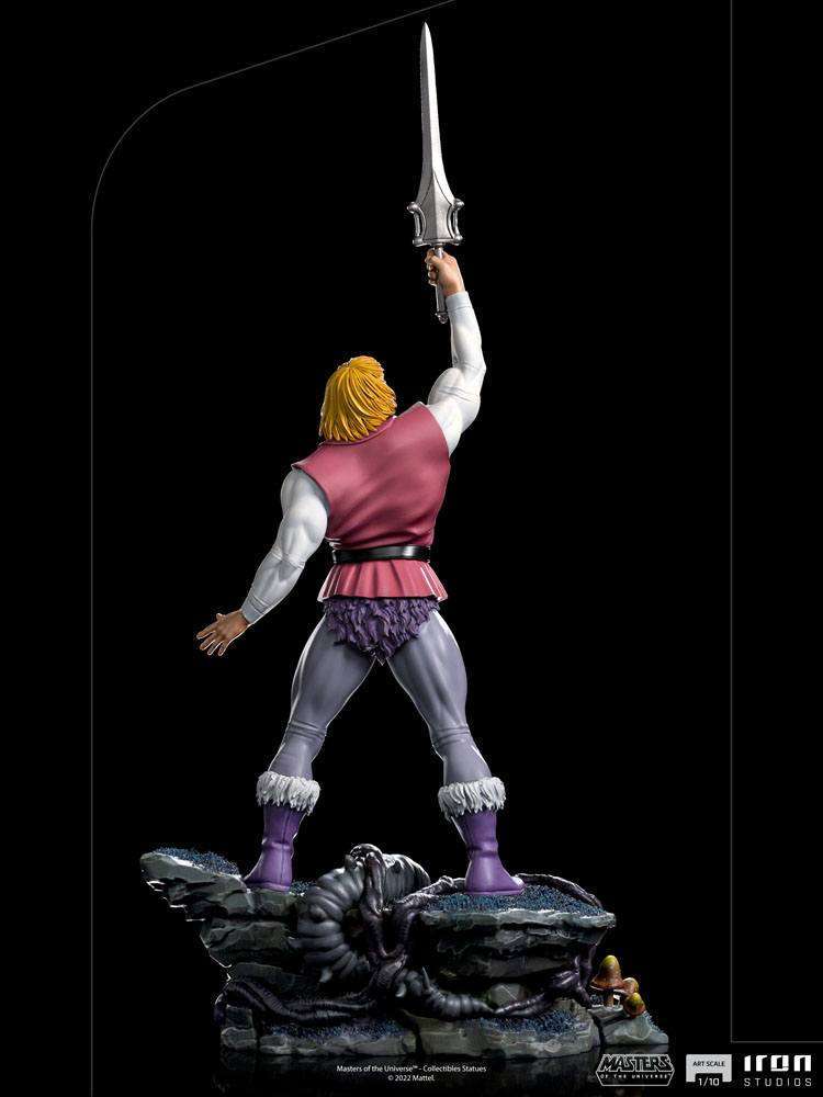 Back view of Iron Studios Prince Adam 1/10 scale statue holding his sword aloft on a rocky, detailed base.
