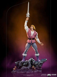 Iron Studios 1/10 Prince Adam statue holding the Power Sword aloft on a rocky, detailed base.