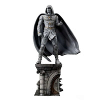 Iron Studios Moon Knight 1/10 scale statue in white mummy-style armor with a flowing cape on a stone pillar base.