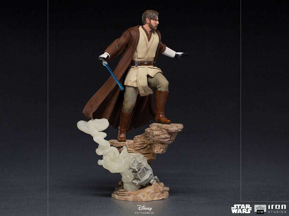 Iron Studios 1/10 Obi-Wan Kenobi statue in a side view, featuring a blue lightsaber and rocky base with smoke effects.