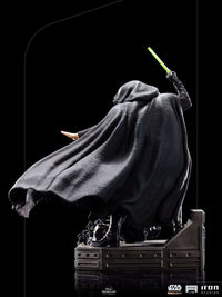 Back view of Iron Studios Luke Skywalker 1/10 scale statue in a black hooded cloak holding a glowing green lightsaber.