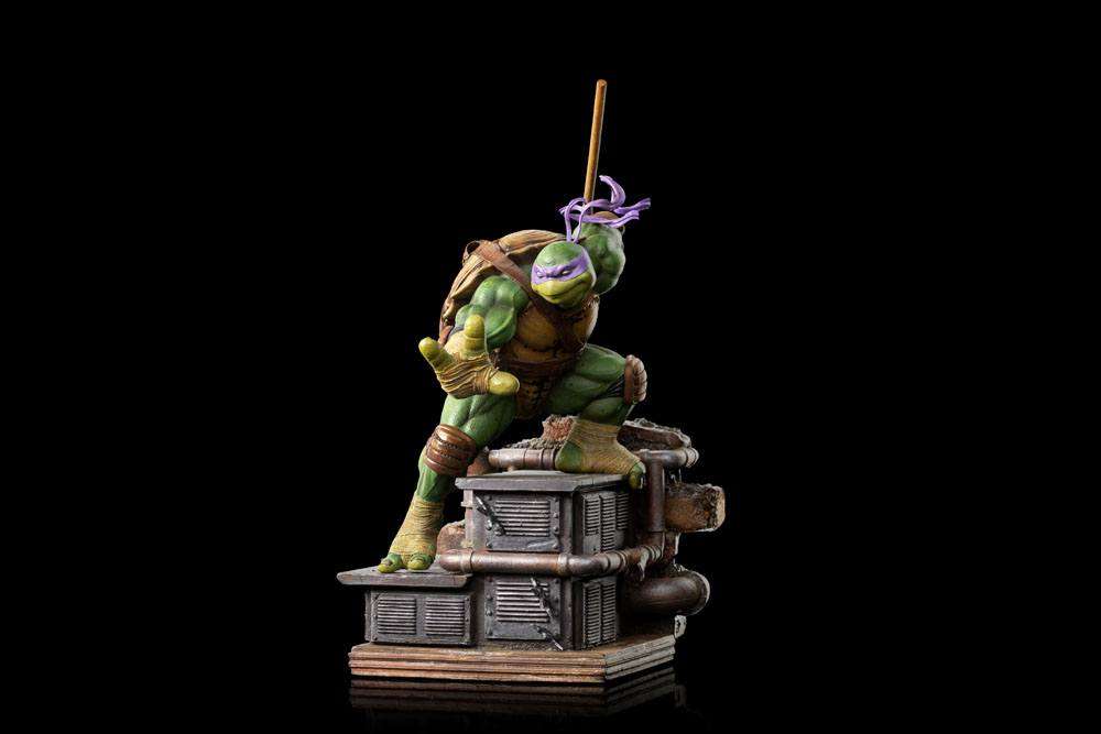 Iron Studios Donatello 1/10 scale statue in a dynamic pose on a detailed industrial rooftop base against black.