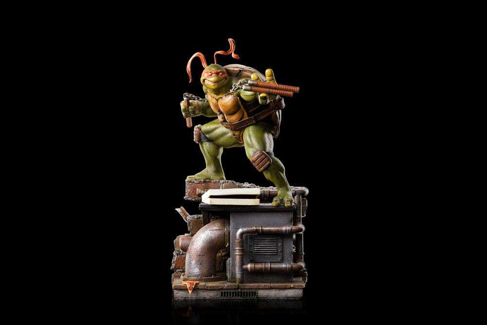 Iron Studios 1/10 Michelangelo statue in a dynamic pose with nunchucks, standing on a detailed sewer base.