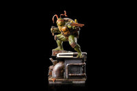Iron Studios 1/10 Michelangelo statue in a dynamic pose with nunchucks, standing on a detailed sewer base.