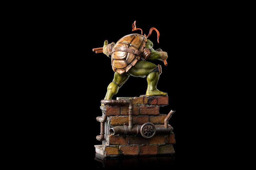 Rear view of Iron Studios Michelangelo 1/10 scale statue, featuring detailed shell and brick base with pipes.