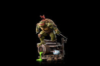 Iron Studios 1/10 Raphael statue in a dynamic pose, featuring green skin, red mask, and twin sai on a sewer base.