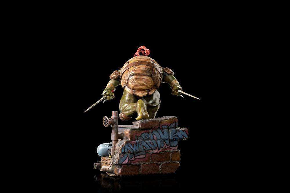 Back view of Iron Studios Raphael 1/10 scale statue, showing his shell, red mask tie, and sai weapons on a brick base.