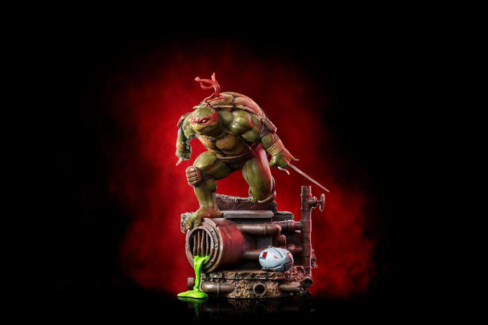 Iron Studios Raphael 1/10 scale statue featuring the turtle in a dynamic pose on a sewer-themed base with green ooze.