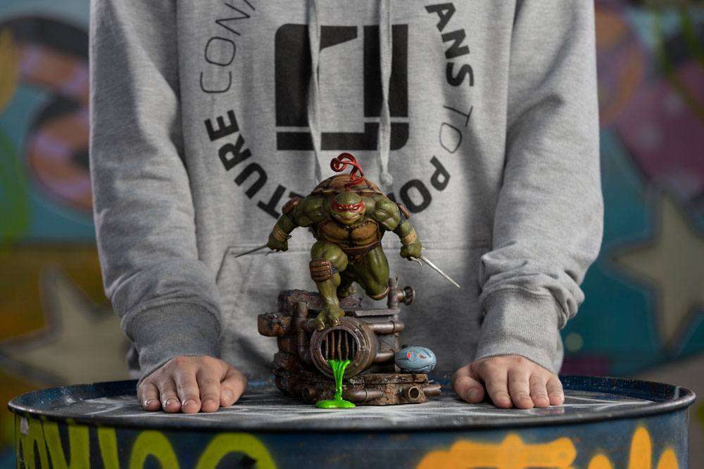 Front view of Iron Studios Raphael 1/10 scale statue, featuring the turtle with sai weapons on a sewer base.