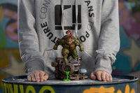 Front view of Iron Studios Raphael 1/10 scale statue, featuring the turtle with sai weapons on a sewer base.