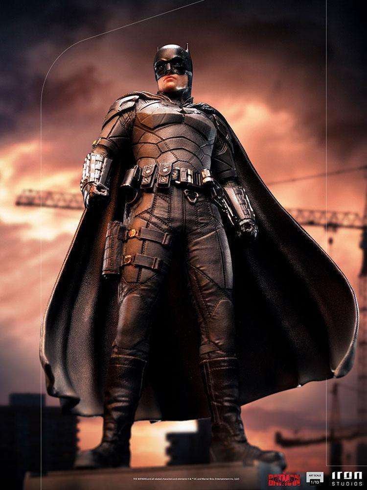 Iron Studios 1/10 scale The Batman statue featuring a detailed black tactical suit and cape against a sunset city backdrop.