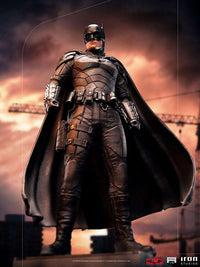 Iron Studios 1/10 scale The Batman statue featuring a detailed black tactical suit and cape against a sunset city backdrop.