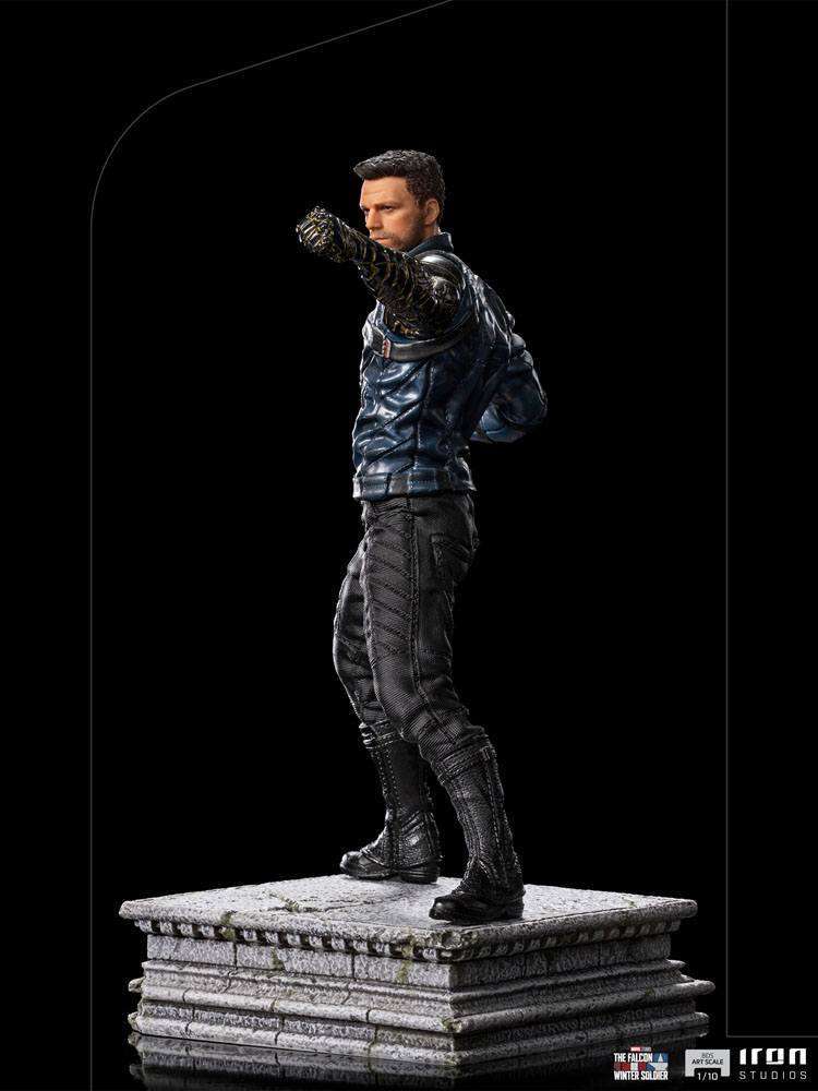 Side view of Iron Studios Bucky Barnes 1/10 scale statue in a blue jacket and black pants on a stone-textured base.
