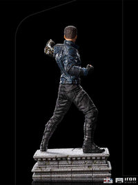 Rear view of Iron Studios Bucky Barnes 1/10 scale statue, featuring his metallic arm and tactical suit on a stone base.