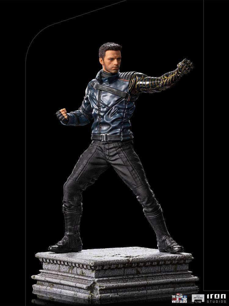 Iron Studios Bucky Barnes 1/10 scale statue in a dynamic combat pose with his metallic arm on a stone-textured base.