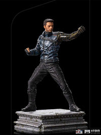 Iron Studios Bucky Barnes 1/10 scale statue in a dynamic combat pose with his metallic arm on a stone-textured base.