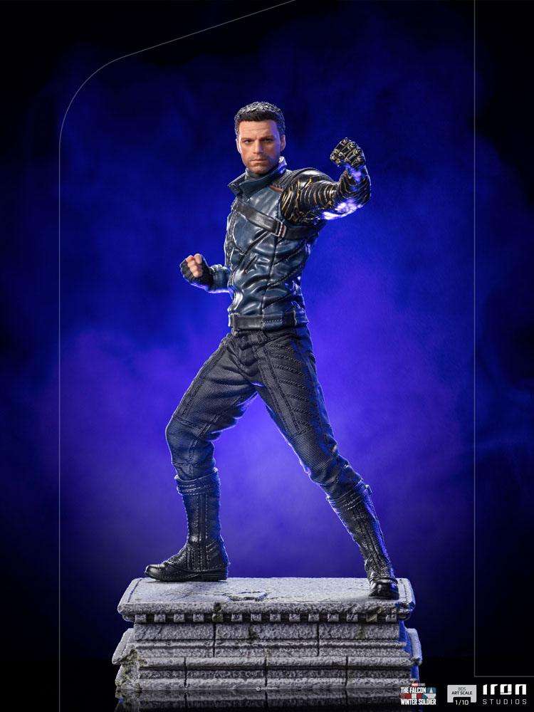 Iron Studios Bucky Barnes 1/10 scale statue in a dynamic combat pose on a stone base against a purple background.