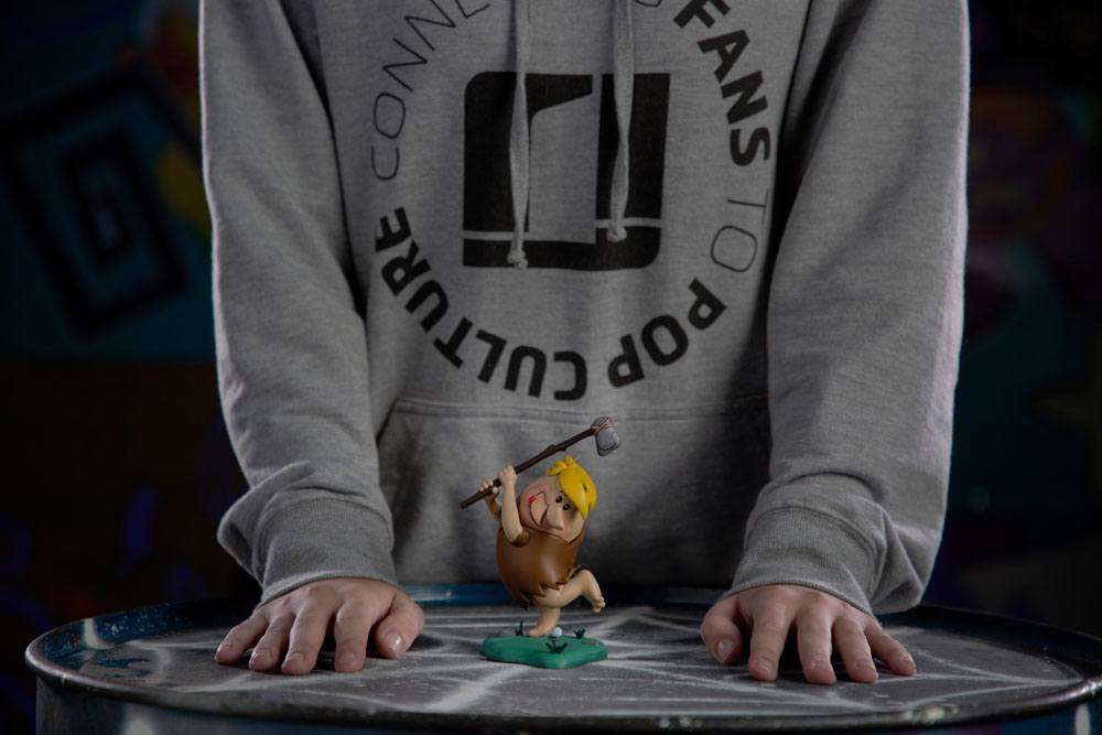 Iron Studios 15 cm Barney Rubble Art Scale statue holding a club, displayed on a table in front of a person.