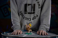 Iron Studios 15 cm Barney Rubble Art Scale statue holding a club, displayed on a table in front of a person.