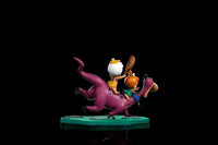 Side view of Iron Studios 1/10 scale Dino, Pebbles, and Bamm-Bamm statue on a green base against a black background.