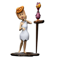Iron Studios Wilma Flintstone 1/10 scale statue in a white dress standing next to a purple bird on a wooden perch.