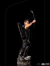 Side view of Iron Studios Hawkeye 1/10 scale statue in black tactical gear, aiming his bow on a rocky base.