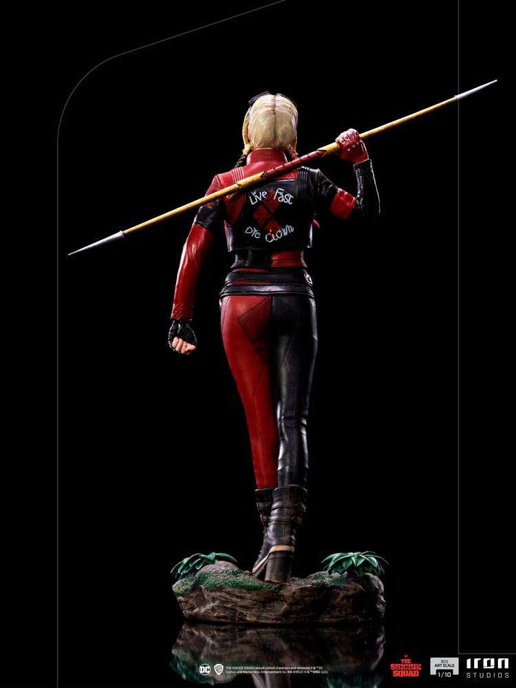 Back view of Iron Studios 1/10 Harley Quinn statue in red and black leather suit holding a spear on a rocky base.