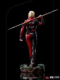 Back view of Iron Studios 1/10 Harley Quinn statue in red and black leather suit holding a spear on a rocky base.