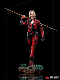 Iron Studios 1/10 Harley Quinn statue from The Suicide Squad, featuring her in a red and black outfit holding a spear.