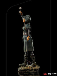 Side view of Iron Studios Ratcatcher II 1/10 scale statue wearing a dark hooded coat and holding a glowing device.