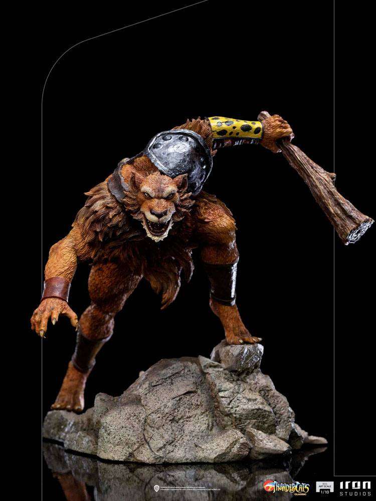 Iron Studios Jackalman 1/10 scale statue in a dynamic, snarling pose, holding a wooden club on a rocky base.