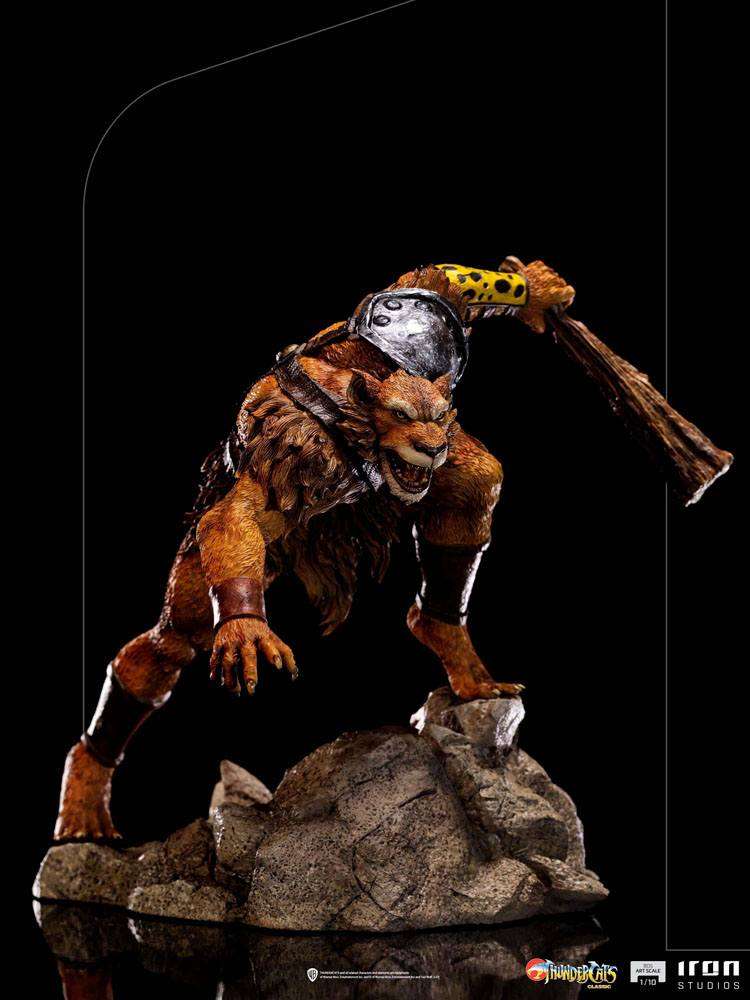 Iron Studios Jackalman 1/10 scale statue in a dynamic crouching pose on a rocky base, holding a wooden club.