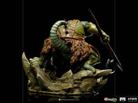 Back view of Iron Studios Slithe 1/10 scale statue, showing green reptilian skin, fur loincloth, and battle axe on rock.