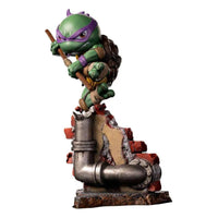 Iron Studios Donatello Mini Co. PVC figure in a dynamic pose with his bo staff atop a broken brick wall base.