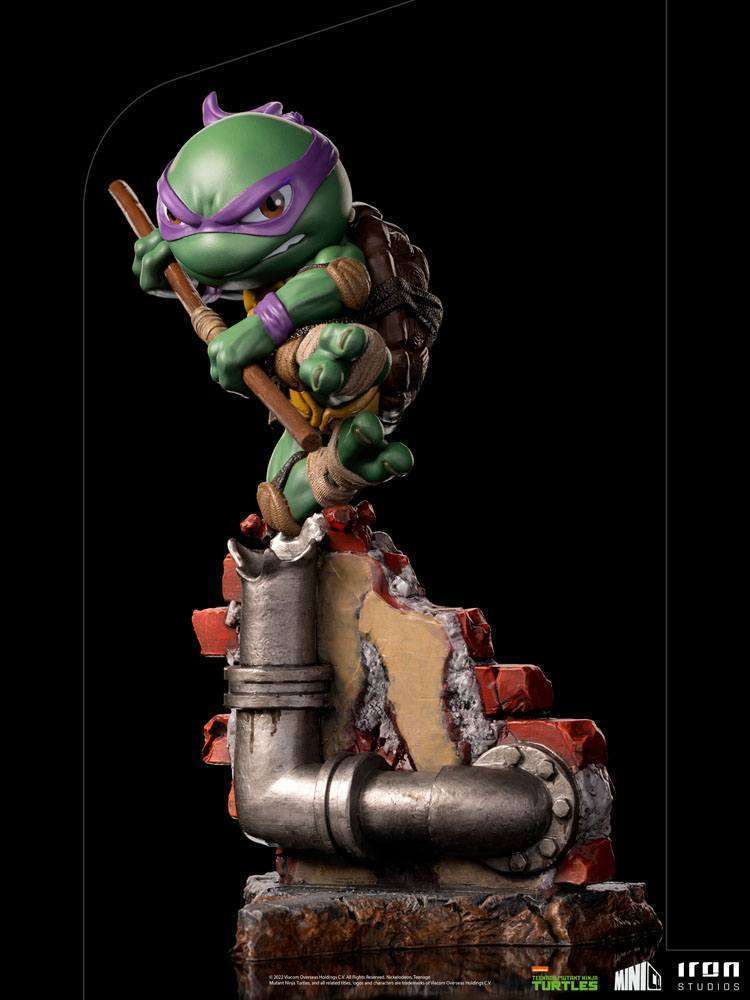 Iron Studios Donatello Mini Co. PVC figure in a dynamic pose with his bo staff atop a brick and pipe base.
