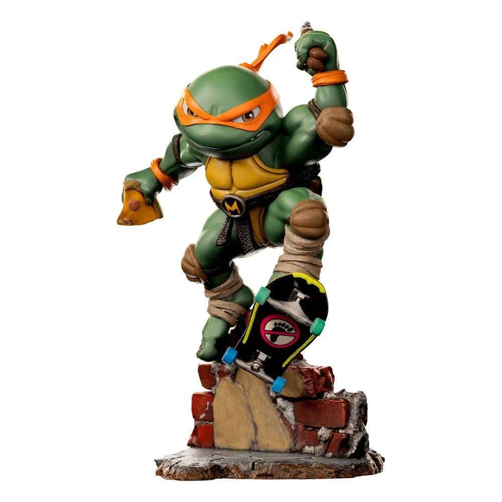 Iron Studios Michelangelo Mini Co. PVC figure on a skateboard, featuring orange mask, pizza slice, and brick base.