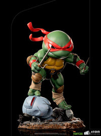 Iron Studios Raphael TMNT Mini Co. 16cm PVC figure in a dynamic front view, wielding twin sai weapons on a rocky base.