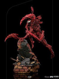 Iron Studios Carnage 1/10 scale statue in a dynamic leaping pose on a brick rubble base, featuring detailed red texture.