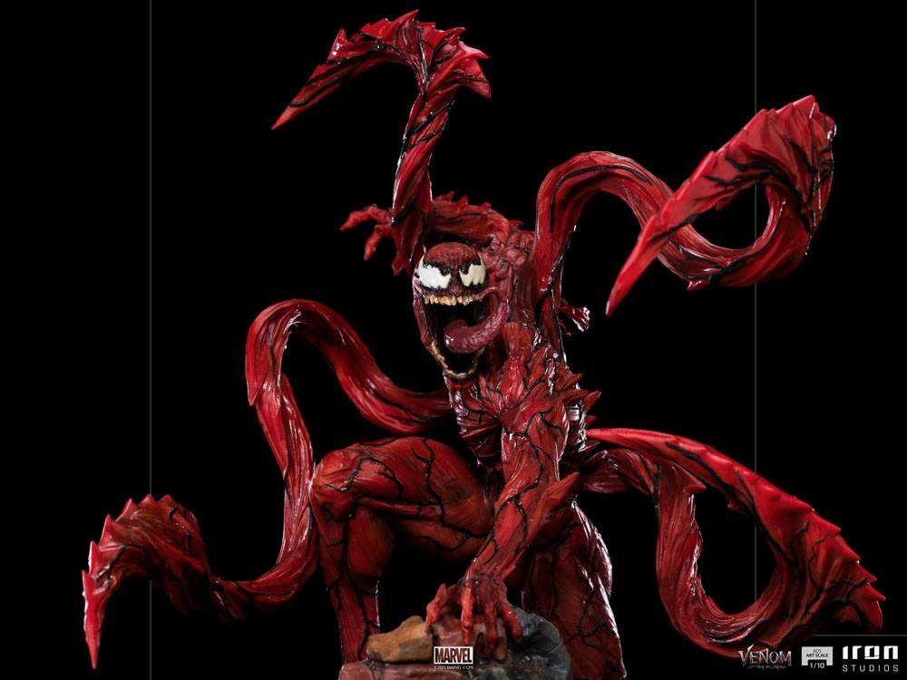 Iron Studios 1/10 Carnage statue from Venom: Let There Be Carnage, featuring a red, tentacled figure on a rocky base.