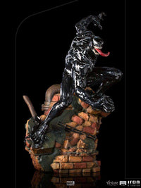 Side view of Iron Studios Venom 1/10 scale statue featuring a glossy black symbiote figure on a brick rubble base.