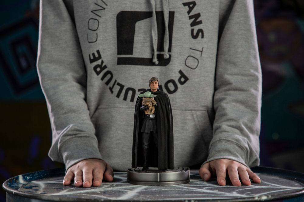 Iron Studios 1/10 scale Luke Skywalker and Grogu statue featuring a black-cloaked Luke holding Grogu on a round base.