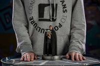 Iron Studios 1/10 scale Luke Skywalker and Grogu statue featuring a black-cloaked Luke holding Grogu on a round base.