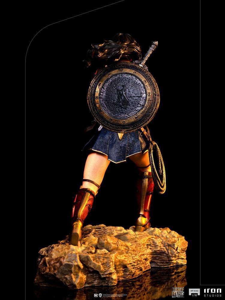 Back view of Iron Studios 1/10 Wonder Woman statue from Justice League, featuring a detailed shield, sword, and rocky base.